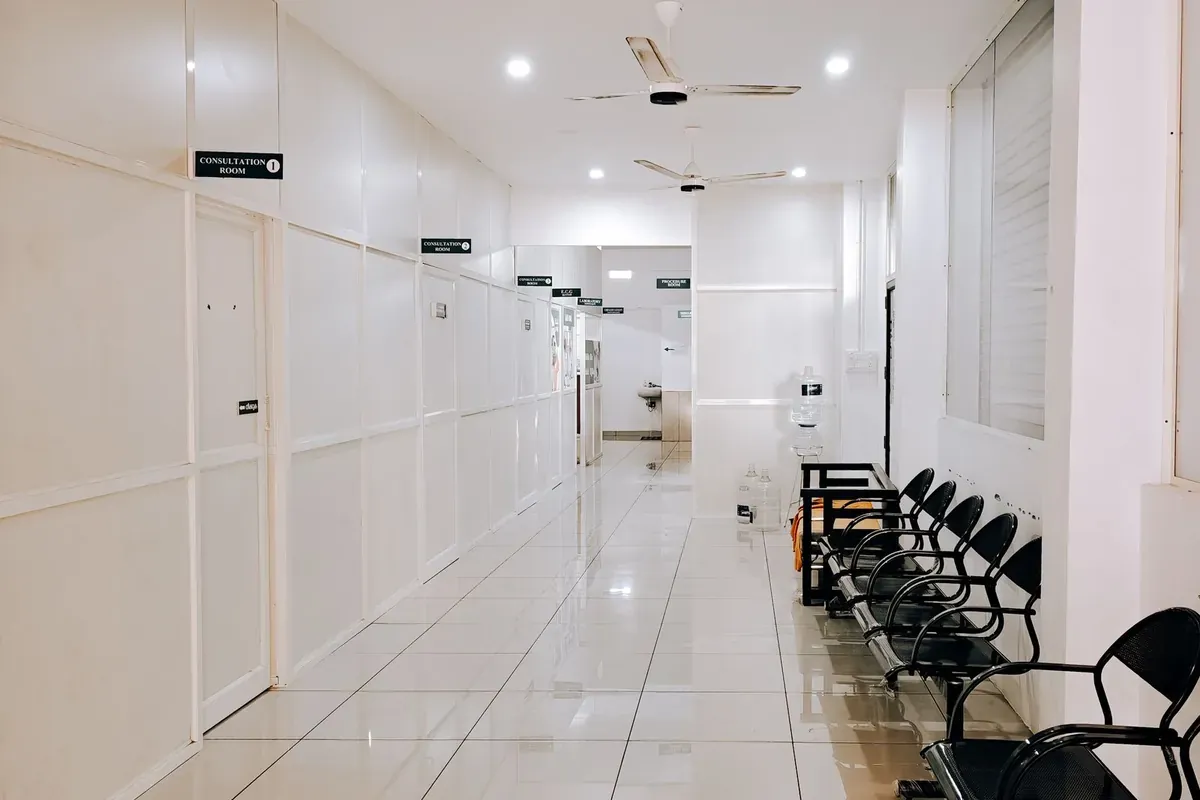 ทางเดินโรงพยาบาลที่ว่างเปล่าขนาบด้วยเก้าอี้นั่งรอ